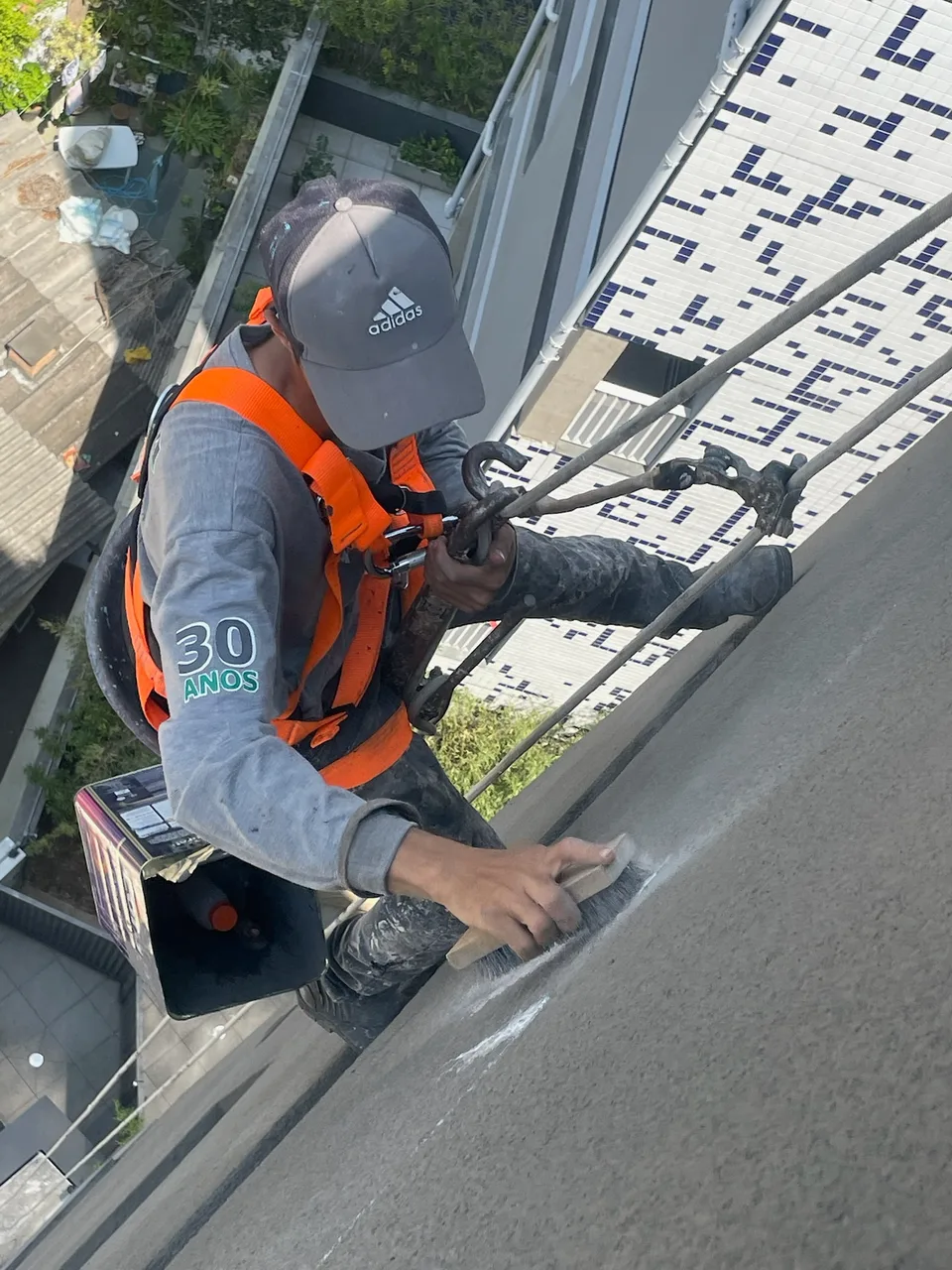 Profissional executando acabamento em fachada predial